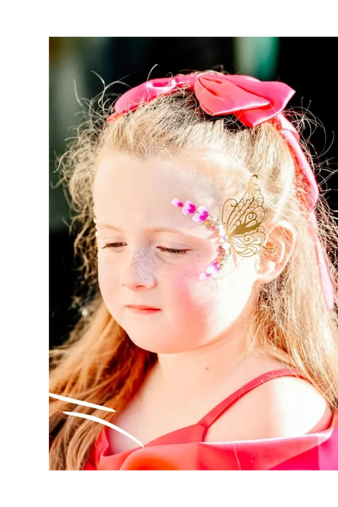 Fille habillée en rouge maquillée avec un bijou de peau papillon et strass
